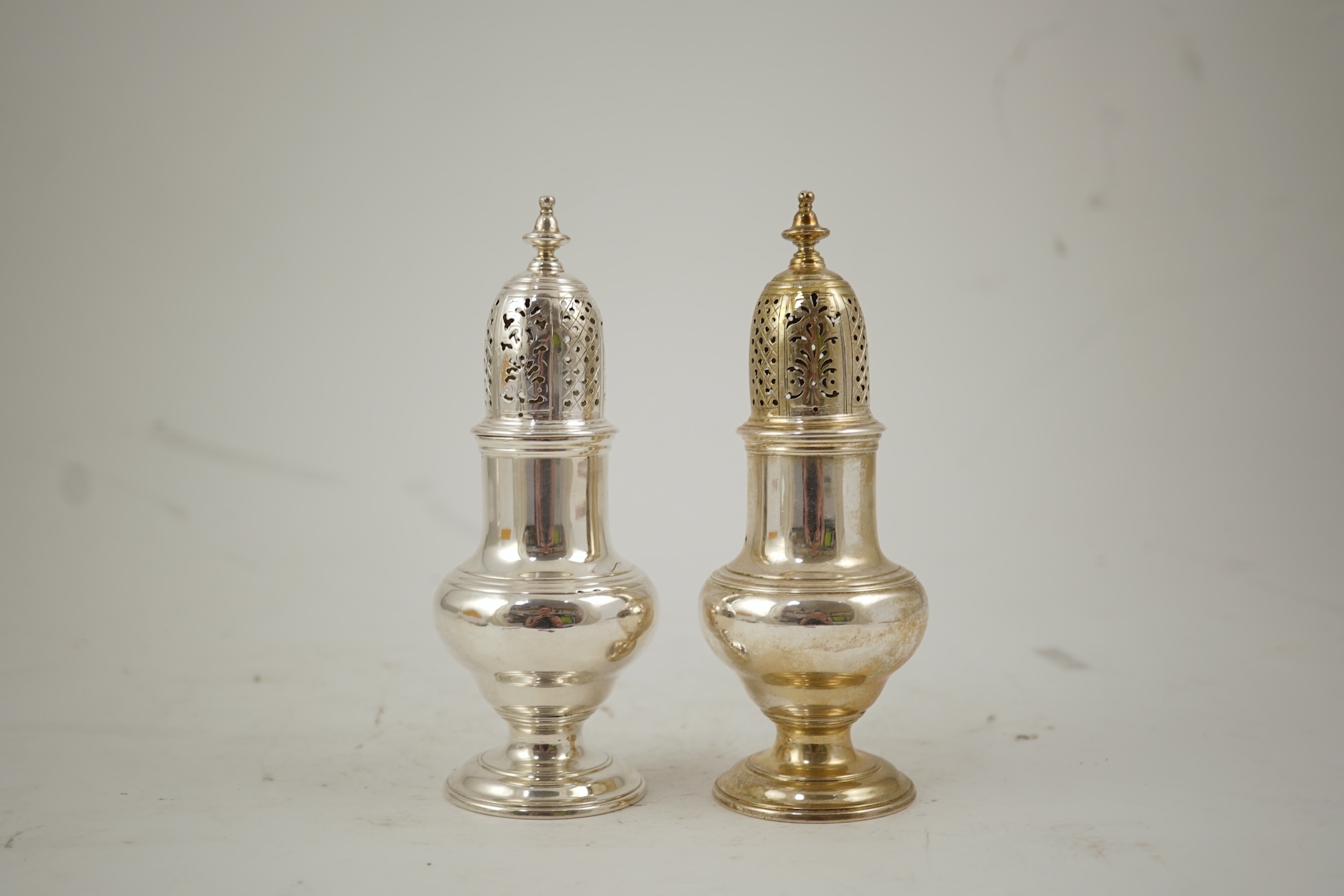 A pair of George II silver baluster sugar casters, by Samuel Wood